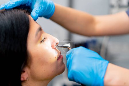 Foto de Primer plano médico ENT examina la cavidad nasal del paciente en el consultorio de la clínica con herramientas profesionales - Imagen libre de derechos