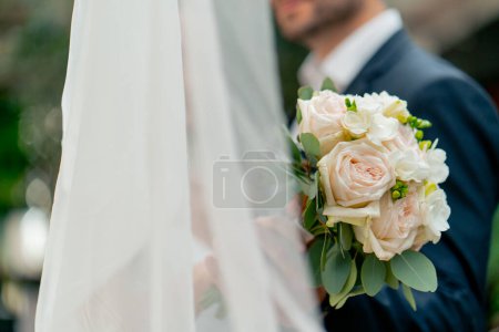 Foto de Primer plano del ramo de flores de la novia durante la ceremonia de celebración de los atributos de la boda - Imagen libre de derechos