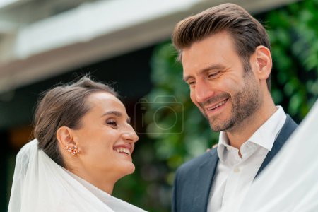 Téléchargez les photos : Portrait d'amoureux heureux mariés en robe blanche et voile sur l'autel jeunes mariés au mariage lors de la cérémonie vœux romantiques - en image libre de droit