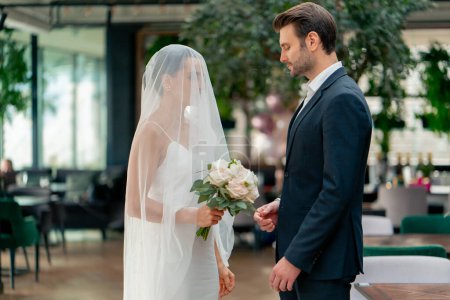 Téléchargez les photos : Portrait d'amoureux heureux mariés en robe blanche et voile sur l'autel jeunes mariés au mariage lors de la cérémonie vœux romantiques - en image libre de droit