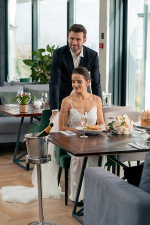 Téléchargez les photos : Portrait d'amoureux souriants marié prend soin des jeunes mariés de la mariée au mariage au restaurant pendant la célébration - en image libre de droit