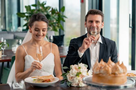 Téléchargez les photos : Portrait de mariée souriante et marié amoureux jeunes mariés au mariage au restaurant lors de la célébration de la romance d'amour avec des verres champagne - en image libre de droit