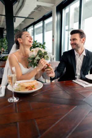 Photo for Portrait of smiling lovers groom giving bouquet to bride newlyweds at wedding in restaurant during celebration love romance - Royalty Free Image