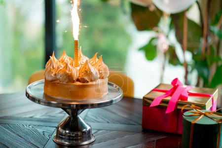Foto de Primer plano de delicioso pastel apetitoso con vela encendida durante el restaurante de celebración de cumpleaños - Imagen libre de derechos