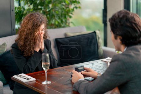 Photo for Portrait of young beautiful curly woman in shock happy with marriage proposal from boyfriend with wedding ring restaurant romance - Royalty Free Image