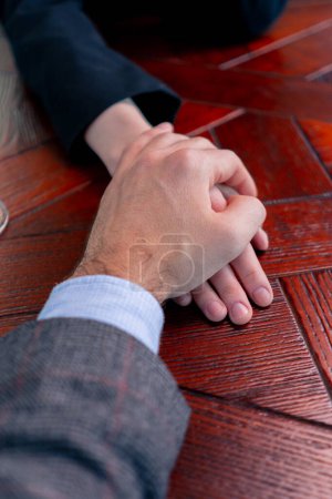 Foto de Primer plano de una pareja enamorada en una cita de la mano en un restaurante concepto amor y apoyo - Imagen libre de derechos