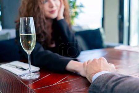 Téléchargez les photos : Gros plan d'un couple amoureux à une date se tenant la main dans un concept de restaurant amour et soutien - en image libre de droit