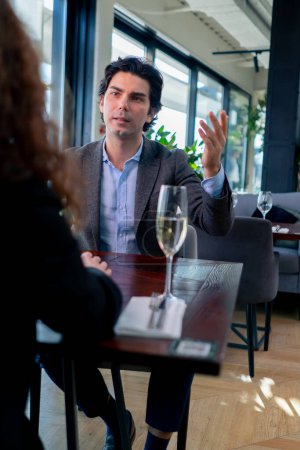 Foto de Un hombre de negocios llama a un camarero para hacer un pedido en un establecimiento de élite el concepto de hospitalidad y servicio - Imagen libre de derechos