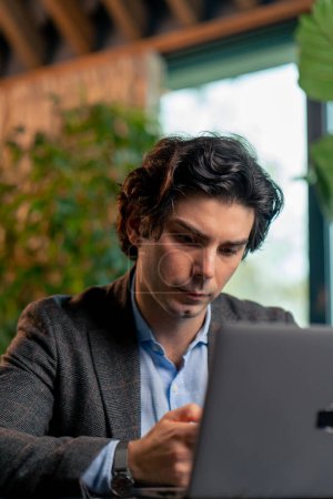 Téléchargez les photos : Portrait d'un homme d'affaires sérieux financier travaillant sur un projet important à l'ordinateur portable dans le bureau - en image libre de droit