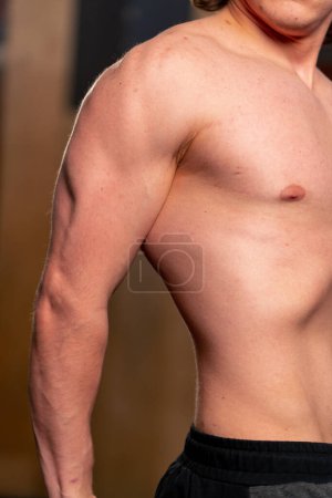 Photo for Close-up in sports club pumped up part of the trainer s arm and torso - Royalty Free Image