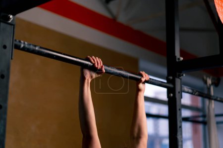 Foto de Primer plano en el gimnasio una chica entrenador en leggings negro y una parte superior pesa sobre la barra horizontal - Imagen libre de derechos