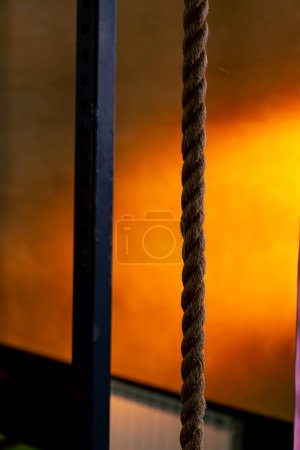 Téléchargez les photos : Gros plan des cordes pour l'exercice dans un club de sport sur un fond orange vif - en image libre de droit