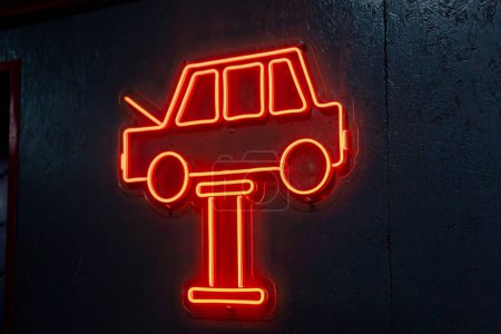 Téléchargez les photos : Close-up À la station-service, il y a un néon en forme de voiture rouge suspendue au mur - en image libre de droit