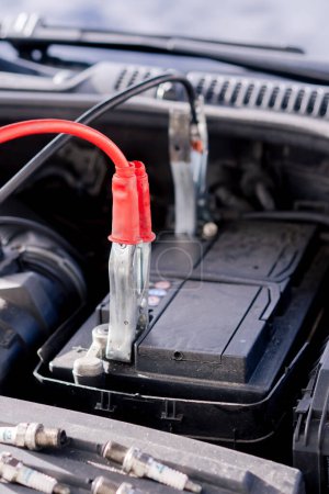 Téléchargez les photos : Close-up Dans une station-service batterie dans une voiture avec pinces connectées pour charger la batterie - en image libre de droit