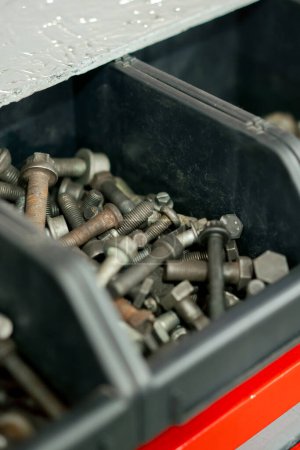 Foto de Close-up En una estación de servicio se utilizan tornillos oxidados en una caja de reutilización de piezas - Imagen libre de derechos