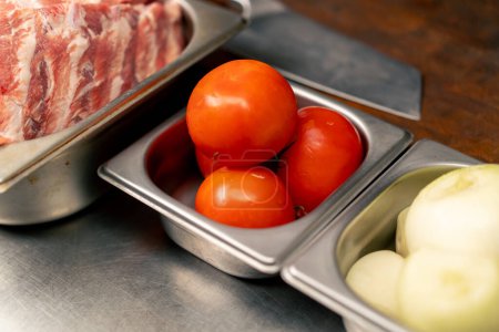 Téléchargez les photos : Close up Dans une cuisine professionnelle en côtelettes légumes pour cuisiner les côtes allongées sur une table en fer - en image libre de droit