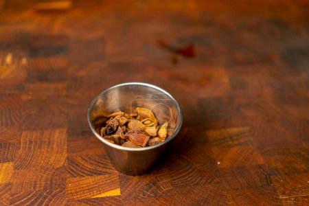 Photo for Close-up in a professional kitchen on wooden board in an iron small bowl of spices - Royalty Free Image