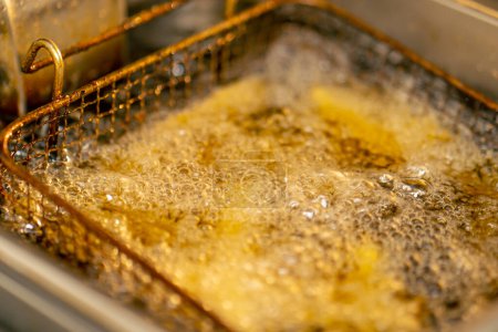 Photo for Close-up in a professional kitchen frying French fries in oil in a deep fryer - Royalty Free Image