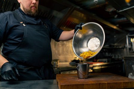 Foto de Primer plano en la cocina profesional el chef vierte papas fritas en un cubo de hierro - Imagen libre de derechos