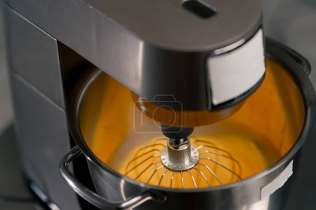 Foto de Primer plano en una máquina de cocina profesional vence a los huevos hasta que la crema de preparación cremosa para un pastel - Imagen libre de derechos