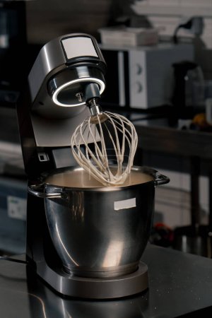 close-up in professional kitchen machine after beating eggs whisk in cream