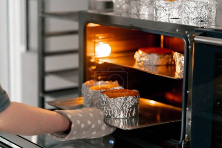 Foto de Primer plano En una cocina profesional un panadero saca galletas preparadas del horno - Imagen libre de derechos