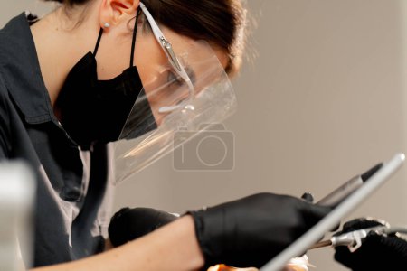 Foto de Dentista odontológica chica haciendo limpieza a un chico joven antes del procedimiento de blanqueamiento - Imagen libre de derechos