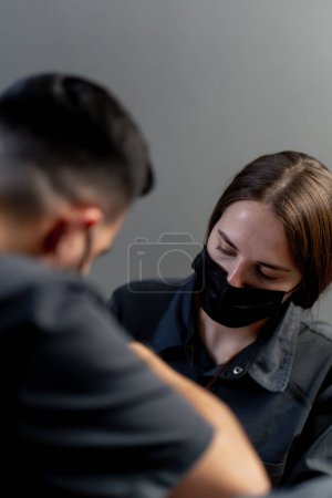 Foto de Primer plano en un consultorio dental un hombre dentista con un asistente da una inyección anestésica a una joven hermosa chica - Imagen libre de derechos