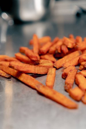 Foto de Primer plano de las batatas de naranja que yacen sobre una mesa de metal para enfriar los alimentos a pedido - Imagen libre de derechos