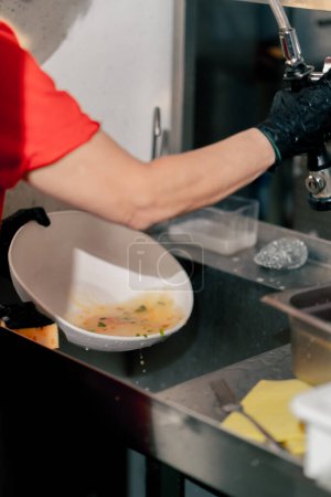 Foto de Primer plano de una mujer lavando platos sucios en la cocina después de usar equipo profesional - Imagen libre de derechos