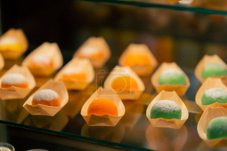 Photo for Close-up on the shop window there are Japanese buns of different colors in craft paper - Royalty Free Image
