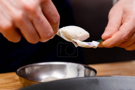 Foto de Primer plano de un tazón de salsa blanca que está tratando de formar con dos cucharaditas - Imagen libre de derechos