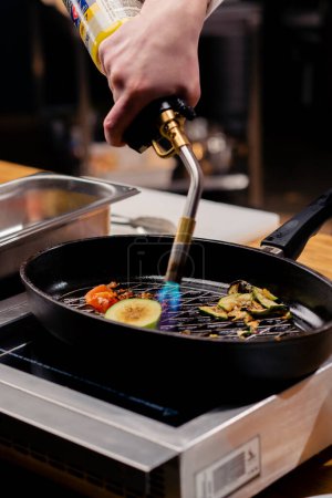 Téléchargez les photos : Gros plan de différents légumes friture sur la cuisinière avec un brûleur dans une poêle à frire chaude - en image libre de droit
