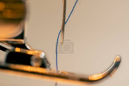 Photo for Close-up in sewing workshop thread is inserted into a needle on a machine - Royalty Free Image