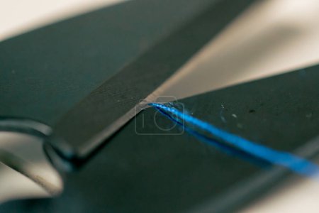 Foto de Muy cerca en un taller de costura tijeras para trabajar en tela con hilo azul - Imagen libre de derechos