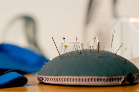 Photo for Close-up in a sewing workshop a pin cushion is completely stuffed with needles and pins - Royalty Free Image