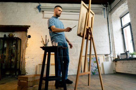 Téléchargez les photos : Général tourné dans un atelier d'art d'une toile sur laquelle sont peintes des touches roses - en image libre de droit