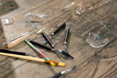 Téléchargez les photos : Gros plan dans un atelier d'art verre cassé sur le sol avec des brosses et des couteaux de palette - en image libre de droit