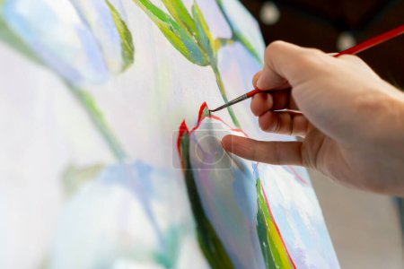 Photo for Close up in an art studio painting with flowers the artist sitting the details on the painting with red paint - Royalty Free Image