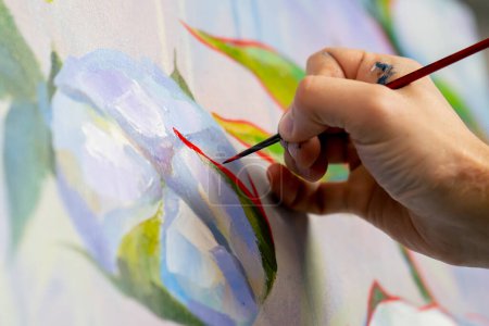 Téléchargez les photos : Fermer dans un atelier d'art peinture avec des fleurs l'artiste assis les détails sur la peinture avec de la peinture rouge - en image libre de droit