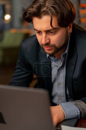 Photo for Close-up top shot in the office the face of worker working hard at a laptop an important deal - Royalty Free Image