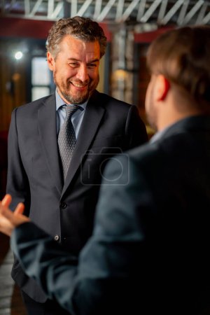 Foto de Primer plano en la oficina el director y un empleado están de pie y discutir el problema el director sonríe y tranquiliza - Imagen libre de derechos