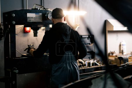 Photo for At a service station an auto mechanic works with a disk from car on a special press - Royalty Free Image