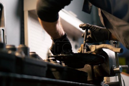 Photo for Close-up at a service station the hands of a car mechanic are standing at the machine and doing repairs - Royalty Free Image