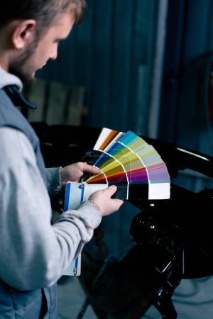 Photo for Hand at a service station a master master selects a paint color on a color palette - Royalty Free Image