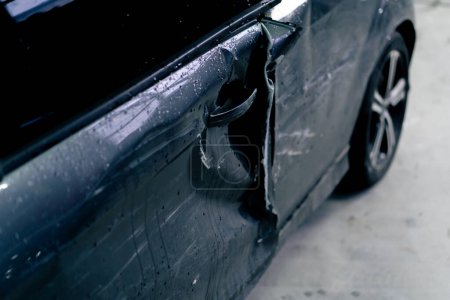 Téléchargez les photos : Gros plan à une station-service d'une porte latérale endommagée du côté conducteur d'une voiture après un accident - en image libre de droit