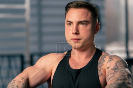 Photo for Close-up of the face of a young handsome muscular trainer with tattoos in the gym - Royalty Free Image