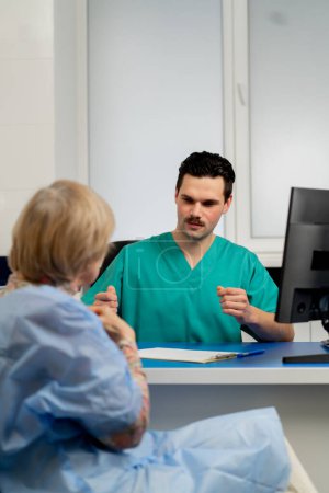 Téléchargez les photos : Consultation entre un médecin et un patient âgé dans une clinique de chirurgie plastique - en image libre de droit