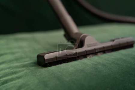 Foto de Primer plano de un cepillo de sierra el proceso de limpieza de un sofá de terciopelo verde muebles para el hogar limpieza limpieza - Imagen libre de derechos
