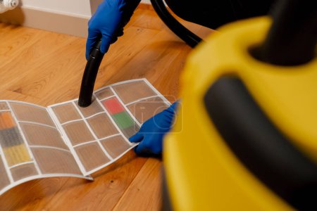Téléchargez les photos : Dans un appartement, un nettoyeur nettoie la surface du lavabo avec une brosse à poussière - en image libre de droit
